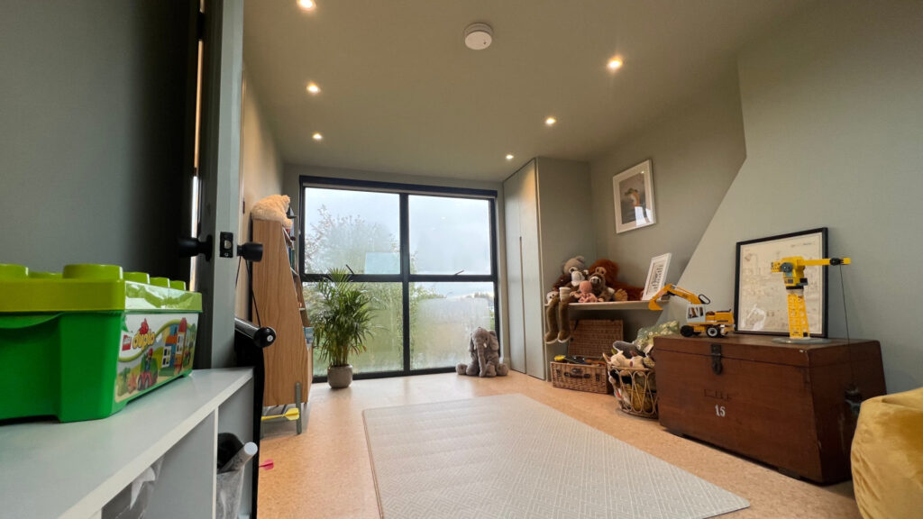 A children's loft bedroom in Catford is full of natural light, making a previously unused attic space into a spacious haven for play.