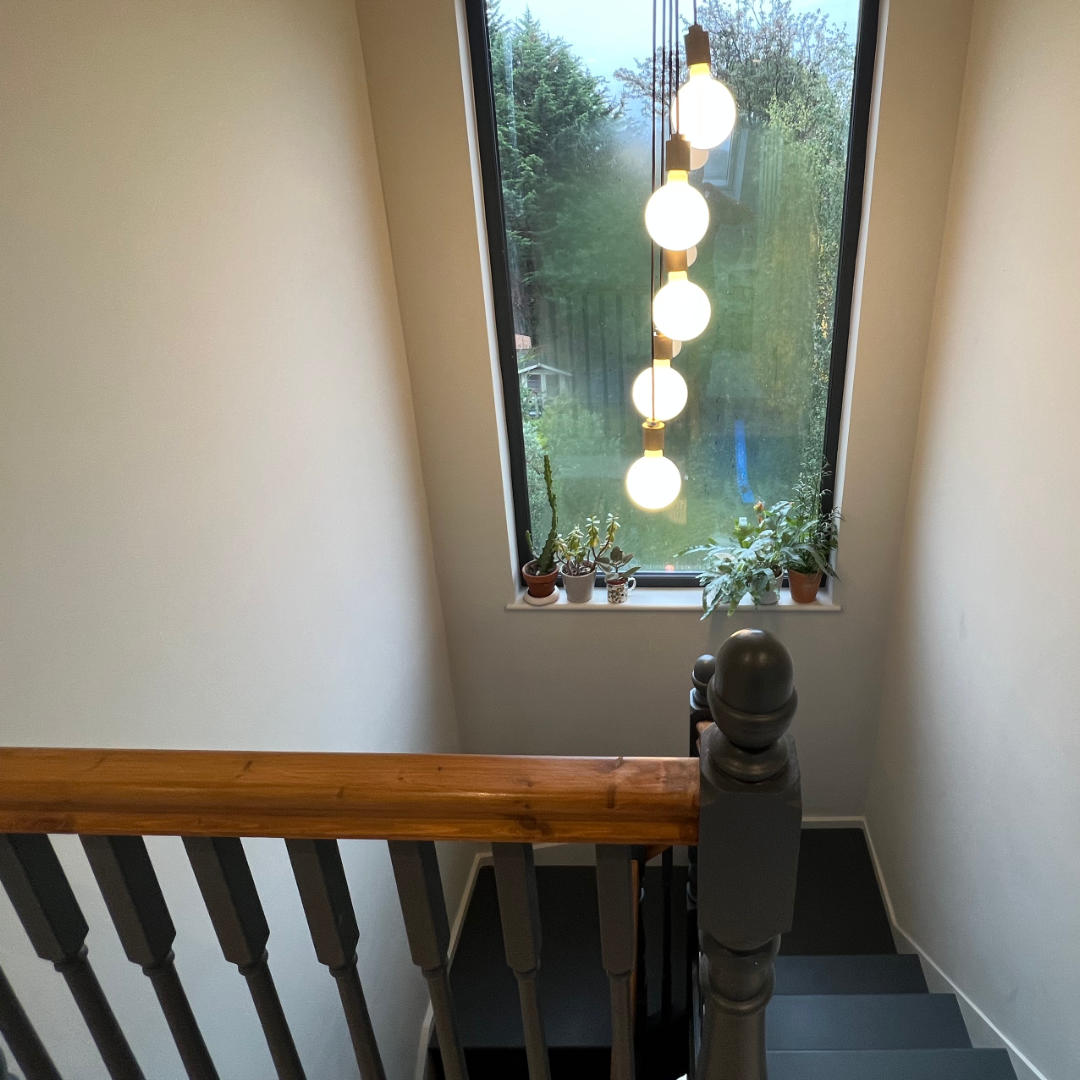 A full-height window allows daylight to flood into this loft staircase in Catford, South London.