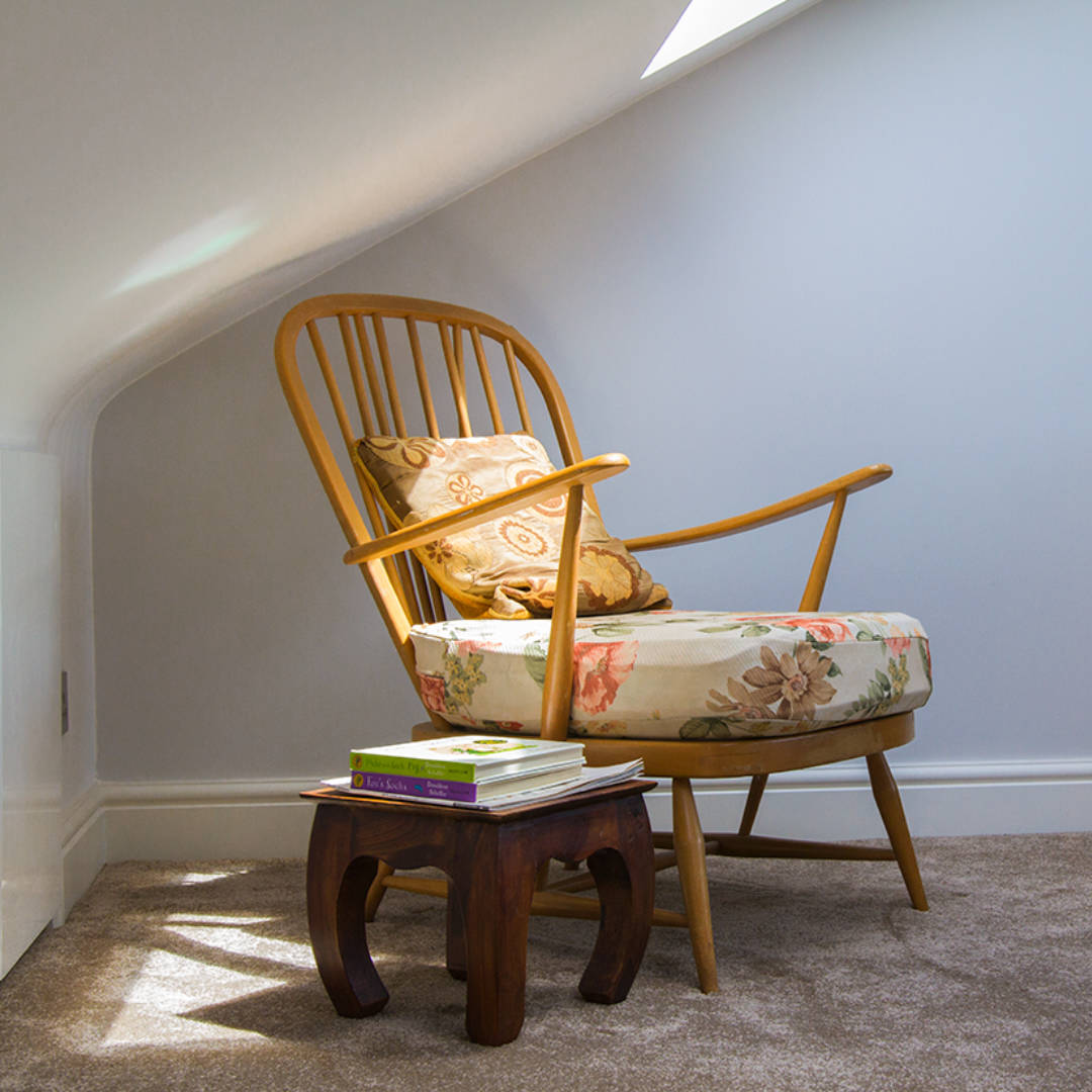 braidwood-road-detail-bedroom-01 A stylish wooden chair sits in a shaft of sunlight beneath a Velux window in a spacious loft bedroom in South London.
