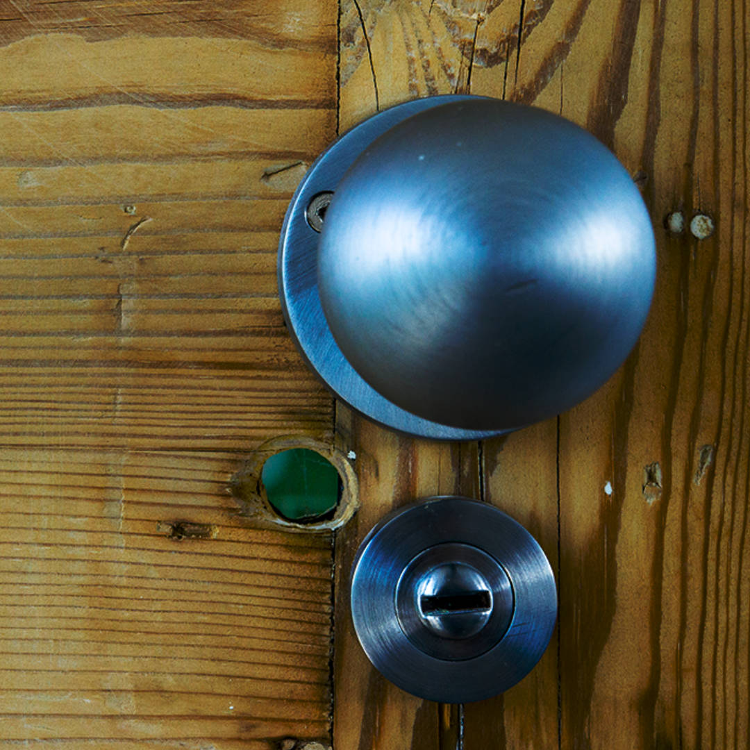 braidwood-road-detail-door-handle Details make the difference! Close-up detail of stylish brushed steel door handle against a reclaimed wooden door in a Catford loft.
